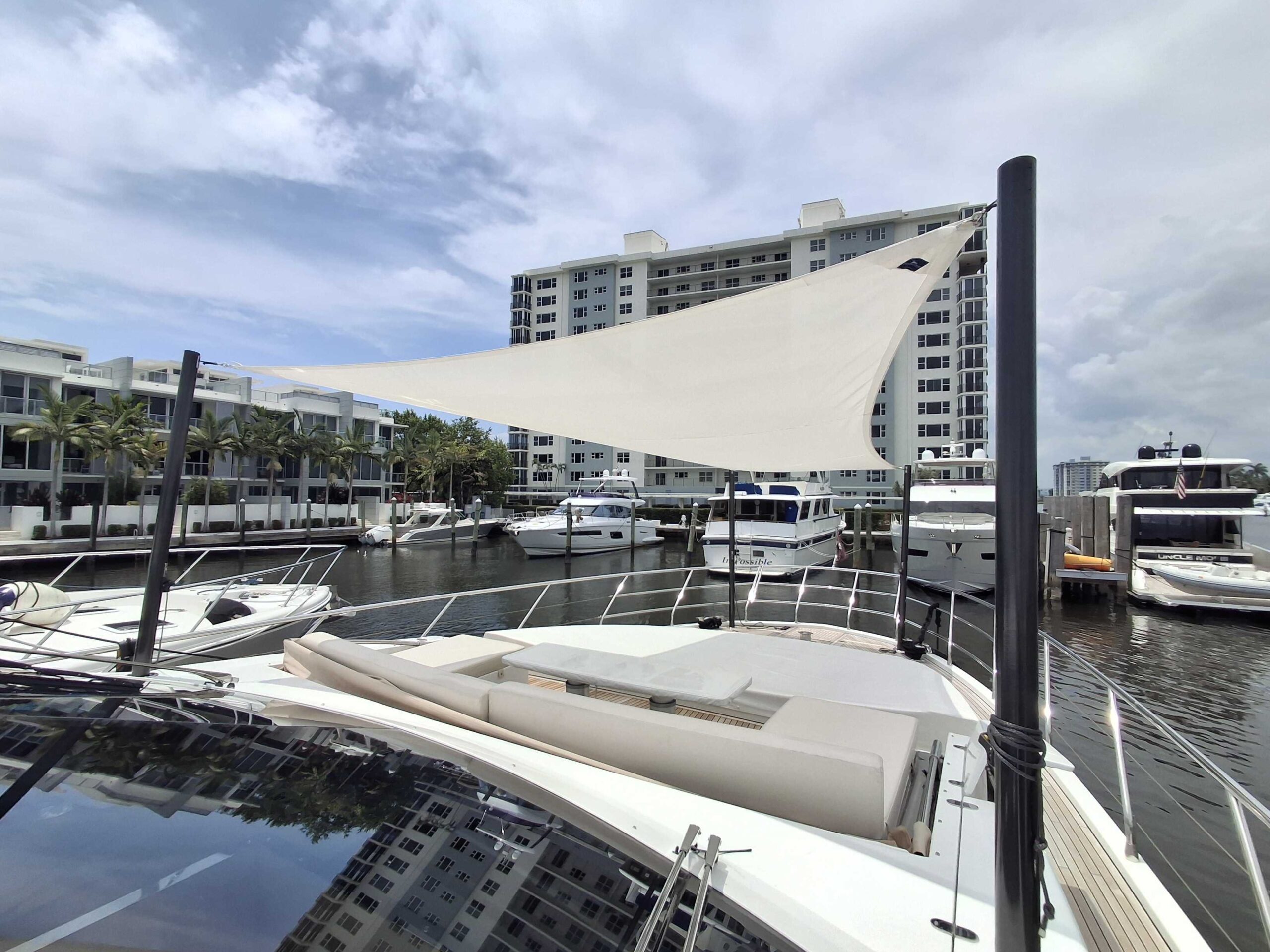 Bow sunshade tensioned between carbon fiber poles over the sunpads of an Azimut 80