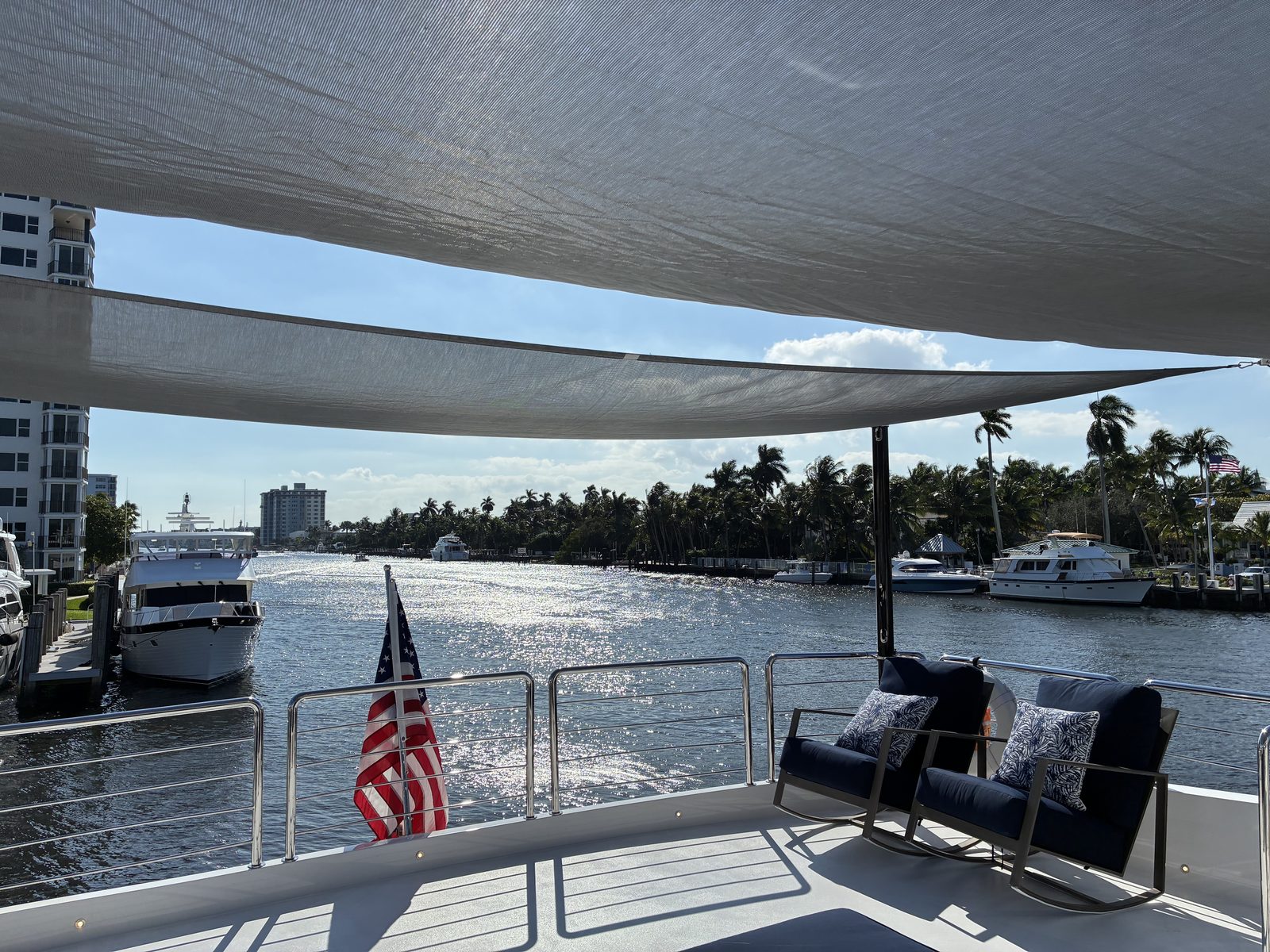 Custom gray sun shades shading the aft deck seating of a 102-foot Horizon yacht on the Intracoastal in South Florida