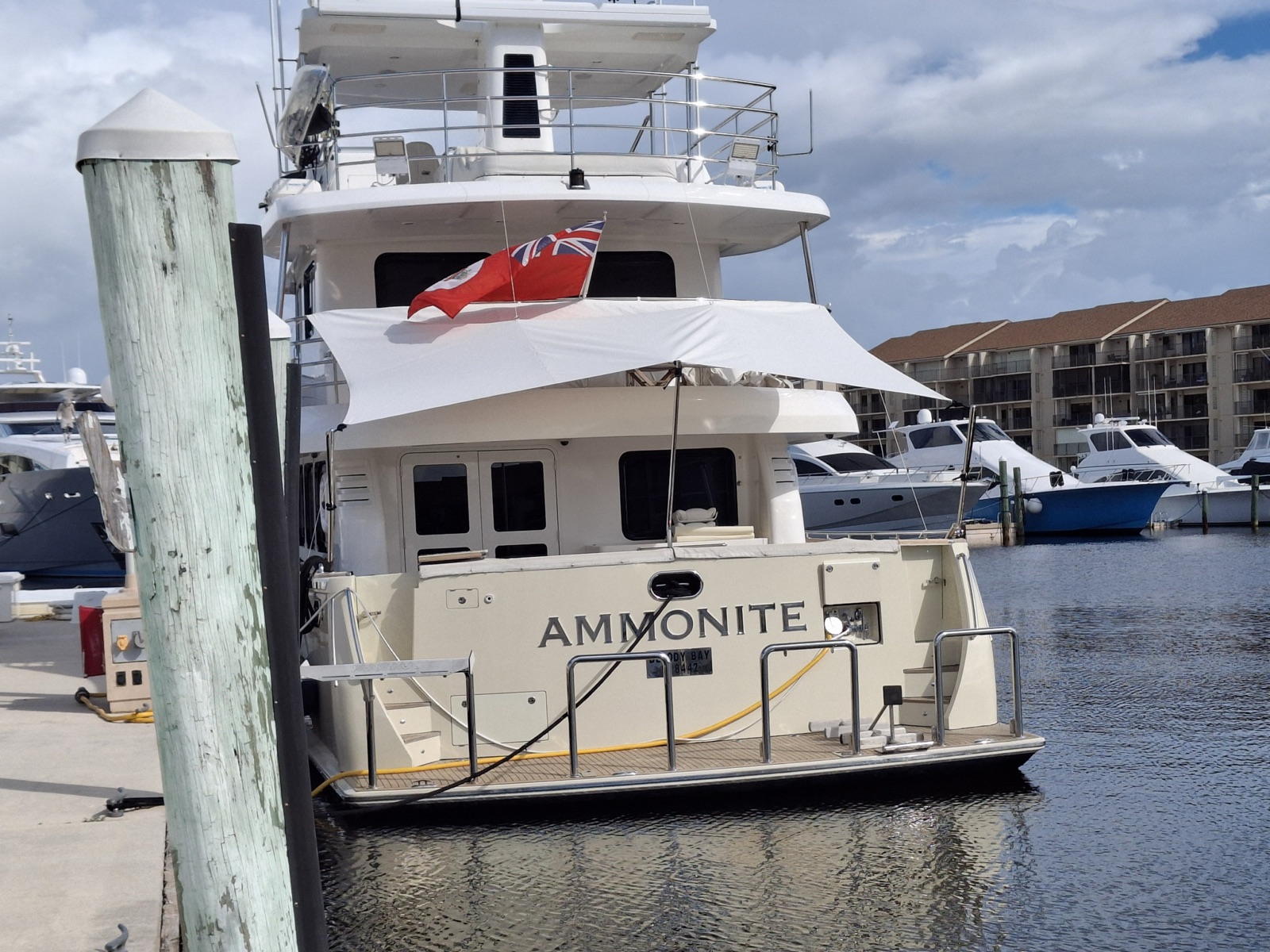 White aft deck sun shade on Ammonite, a Nordhavn 78, seen from the dock in South Florida